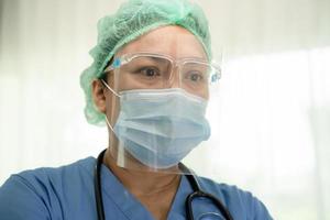 aziatische arts met gezichtsschild en pbm-pak nieuw normaal om te controleren of de patiënt de veiligheid beschermt infectie covid 19 coronavirus uitbraak op quarantaine verpleegafdeling.