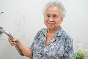 Aziatische senior of oudere oude dame vrouw patiënt gebruik toilet badkamer handvat beveiliging in verpleegafdeling ziekenhuis, gezond sterk medisch concept.