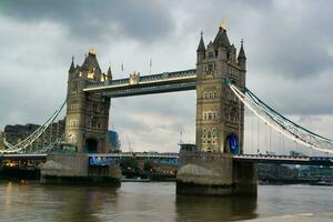 laag hoek visie van centraal Londen stad Bij rivier- Theems en toren Londen brug gedurende een bewolkt dag van juni 18e, 2023. Londen, Engeland, Verenigde koninkrijk, Super goed Brittannië tour. foto