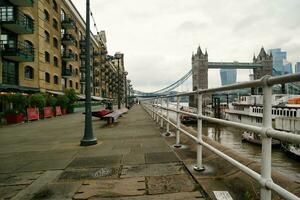 laag hoek visie van centraal Londen stad Bij rivier- Theems en toren Londen brug gedurende een bewolkt dag van juni 18e, 2023. Londen, Engeland, Verenigde koninkrijk, Super goed Brittannië tour. foto