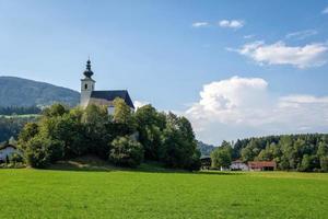 dorp met een kerk in het alpendal bij salzburg. Oostenrijk foto