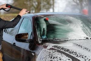 auto zonder aanraking wassen self-service. wassen met water en schuim. foto