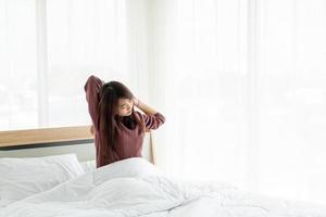 Aziatische vrouw op bed en 's ochtends wakker worden