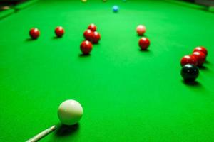 speler schoot bal op groene snookertafel foto