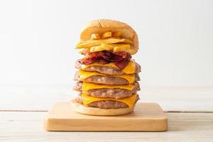 varkenshamburger of varkensburger met kaas, spek en frietjes foto