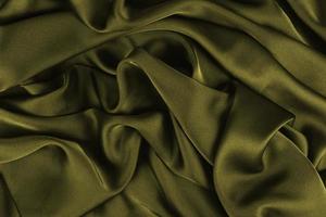 abstracte satijnen zijdeachtige doek, stof textiel draperen met vouw golvende plooien. met zachte golven, zwaaien in de wind. textuur van verfrommeld papier foto