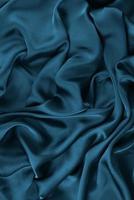 abstracte satijnen zijdeachtige doek, stof textiel draperen met vouw golvende plooien. met zachte golven, zwaaien in de wind. textuur van verfrommeld papier foto
