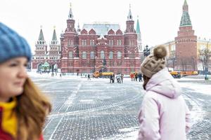 een mooi jong meisje loopt langs het Manezhnaya-plein in Moskou tijdens een sneeuwval en een sneeuwstorm foto