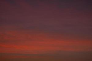 donkere karmozijnrode ochtendhemel van de dageraad op zee foto