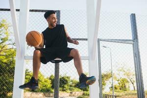 zwart Mens aan het doen sport, spelen basketbal Aan zonsopkomst, actief levensstijl, zonnig zomer ochtend- foto