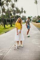 jong elegant hipster paar in liefde Aan vakantie met hond en skateboard foto