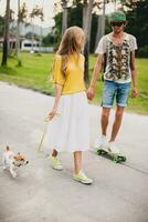 jong elegant hipster paar in liefde Aan vakantie met hond en skateboard foto