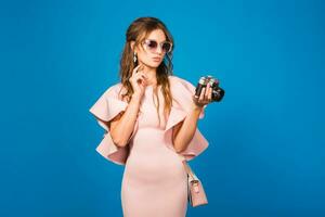 jong elegant sexy vrouw in roze luxe jurk nemen afbeeldingen Aan wijnoogst camera foto