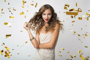 mooi vrouw vieren partij in gouden confetti foto