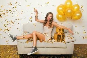 mooi vrouw vieren partij in gouden confetti foto