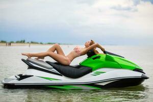 sexy vrouw in bikini Aan water scooter in zee zomer stijl foto