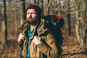 jong hipster Mens op reis met rugzak in voorjaar herfst Woud foto