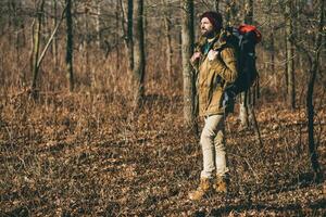 jong hipster Mens op reis met rugzak in voorjaar herfst Woud foto