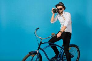 jong knap glimlachen gelukkig Mens op reis Aan hipster fiets foto