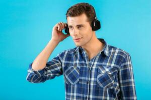 elegant jong Mens luisteren naar muziek- Aan draadloze hoofdtelefoons foto