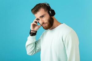 elegant jong Mens luisteren naar muziek- Aan draadloze hoofdtelefoons foto