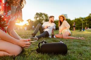 bedrijf van vrienden hebben pret samen in park luisteren naar muziek- foto