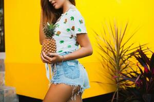 aantrekkelijk glimlachen vrouw Aan vakantie Holding ananas foto
