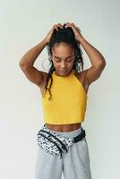 aantrekkelijk zwart Afrikaanse Amerikaans vrouw poseren in elegant hipster kleding Aan wit achtergrond foto