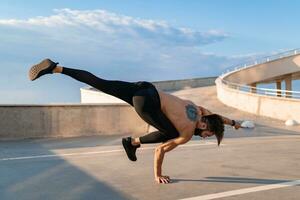 aantrekkelijk knap Mens met atletisch sterk lichaam aan het doen ochtend- yoga asana buitenshuis foto