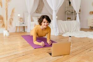jong mooi vrouw aan het doen yoga Bij huis foto