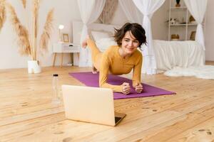 jong mooi vrouw aan het doen yoga Bij huis foto