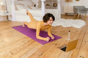 jong mooi vrouw aan het doen yoga Bij huis foto