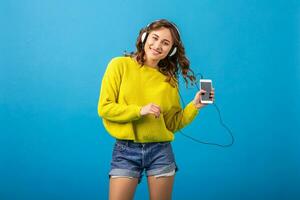aantrekkelijk vrouw in vrolijk verliet humeur luisteren naar muziek- in hoofdtelefoons foto
