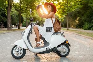 aantrekkelijk vrouw rijden Aan motor in straat foto