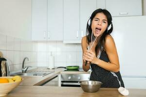 aantrekkelijk glimlachen vrouw in pyjama hebben ontbijt in keuken foto