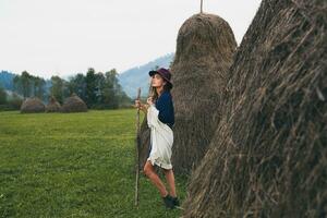 jong elegant vrouw wandelen in platteland in herfst foto