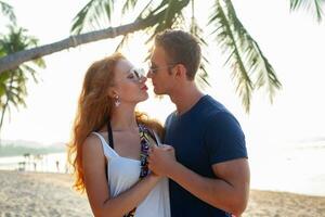 jong paar in liefde gelukkig Aan zomer strand samen hebben pret foto