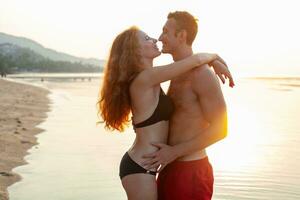 jong sexy romantisch paar in liefde gelukkig Aan zomer strand samen hebben pret vervelend zwemmen pakken foto