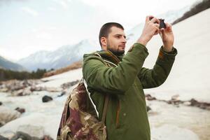 jong hipster Mens wandelen in bergen foto