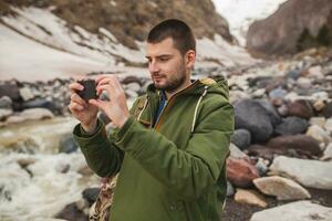 jong hipster Mens wandelen in bergen foto