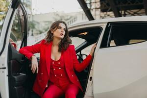 mooi sexy rijk bedrijf vrouw in rood pak poseren in wit auto foto