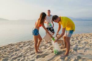 jong mensen vrienden plukken omhoog uitschot en vuilnis Aan tropisch strand foto