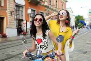 twee jong mooi hipster Dames rijden Aan motor stad straat foto