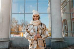 jong glimlachen vrouw wandelen in straat in winter foto