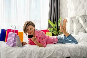 mooi gelukkig vrouw aan het liegen Aan bed Bij huis boodschappen doen online foto