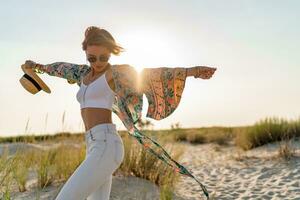 elegant aantrekkelijk slank glimlachen vrouw Aan strand in zomer stijl mode neiging kleding foto