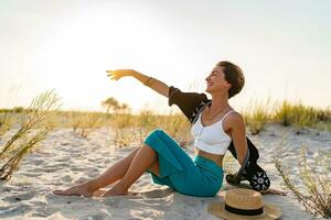 elegant aantrekkelijk vrouw Aan strand in zomer stijl mode neiging kleding gelukkig hebben pret foto