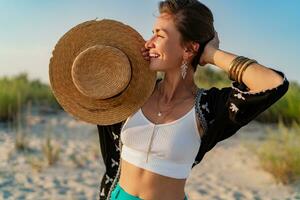 elegant aantrekkelijk vrouw Aan strand in zomer stijl mode neiging kleding gelukkig hebben pret foto