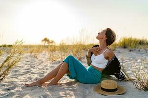 elegant aantrekkelijk vrouw Aan strand in zomer stijl mode neiging kleding gelukkig hebben pret foto