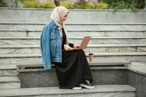 modern elegant moslim vrouw in hijab in stad straat foto